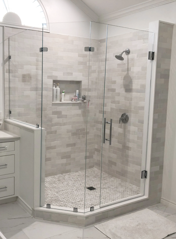 Shower remodel with gray tiled shower wall and glass doors in Highland Park, TX